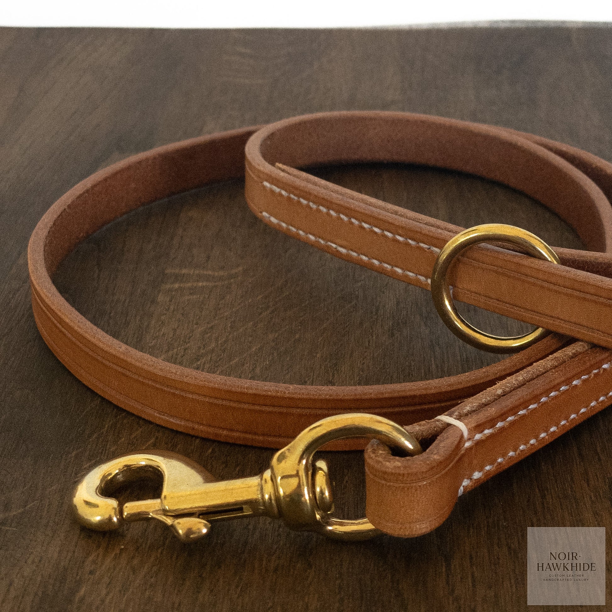 Detailed view of solid brass hardware and hand stitching on handmade leather dog leash.