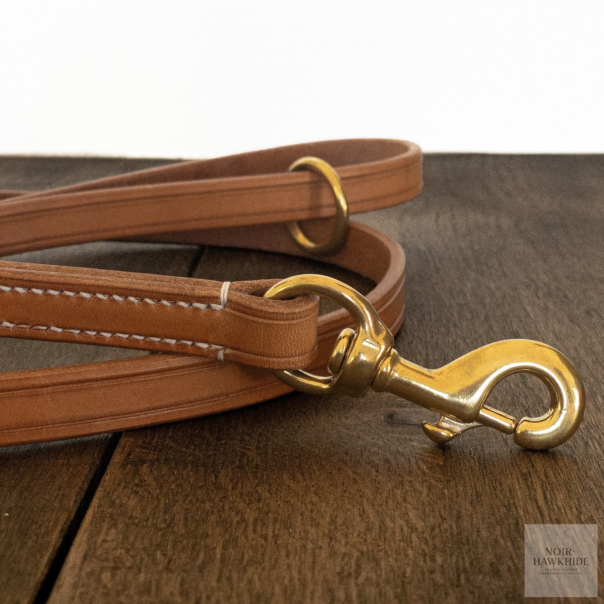 Close-up of handmade leather dog leash with hand stitching and solid brass hardware.