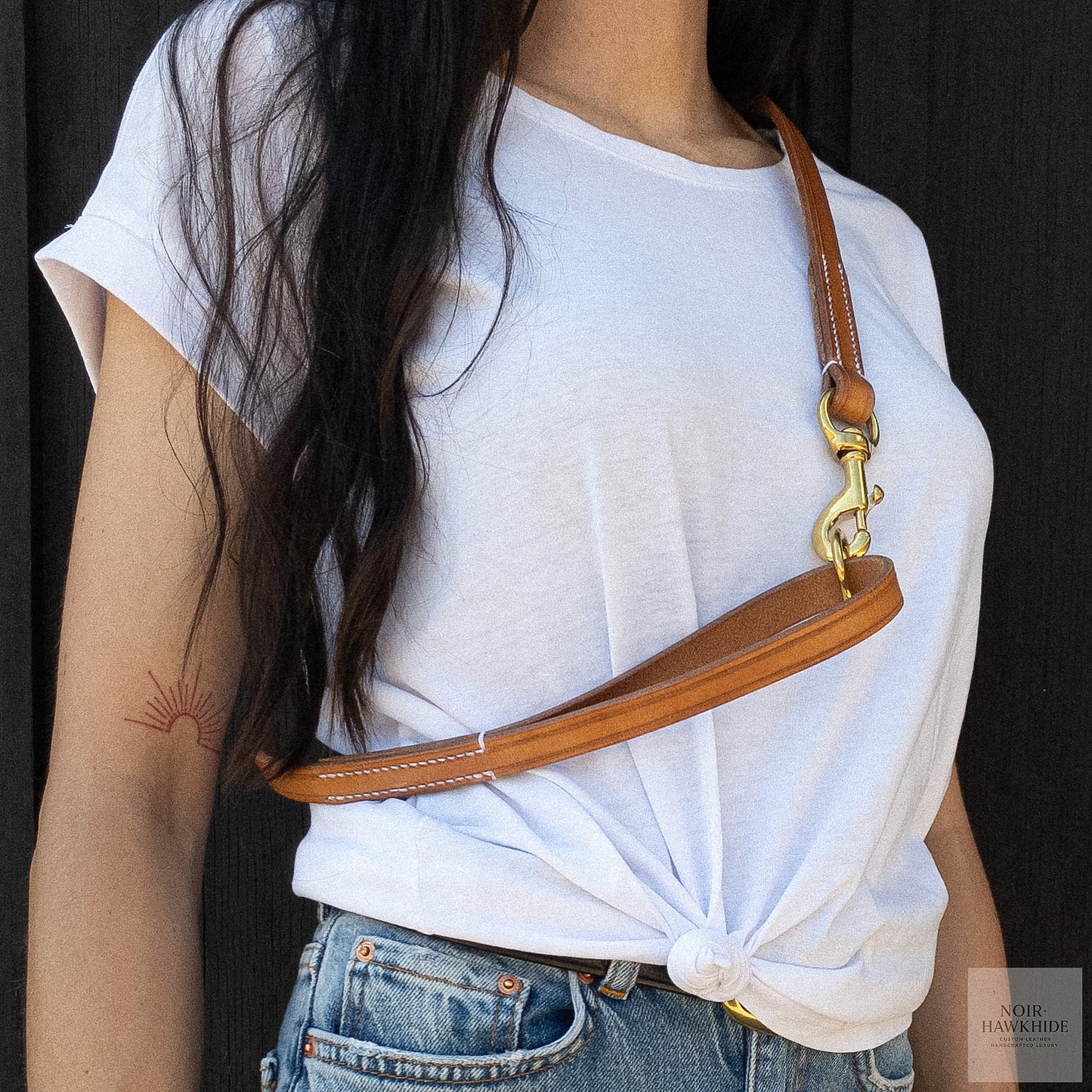 Handmade leather dog leash worn over the shoulder for hands-free carrying.