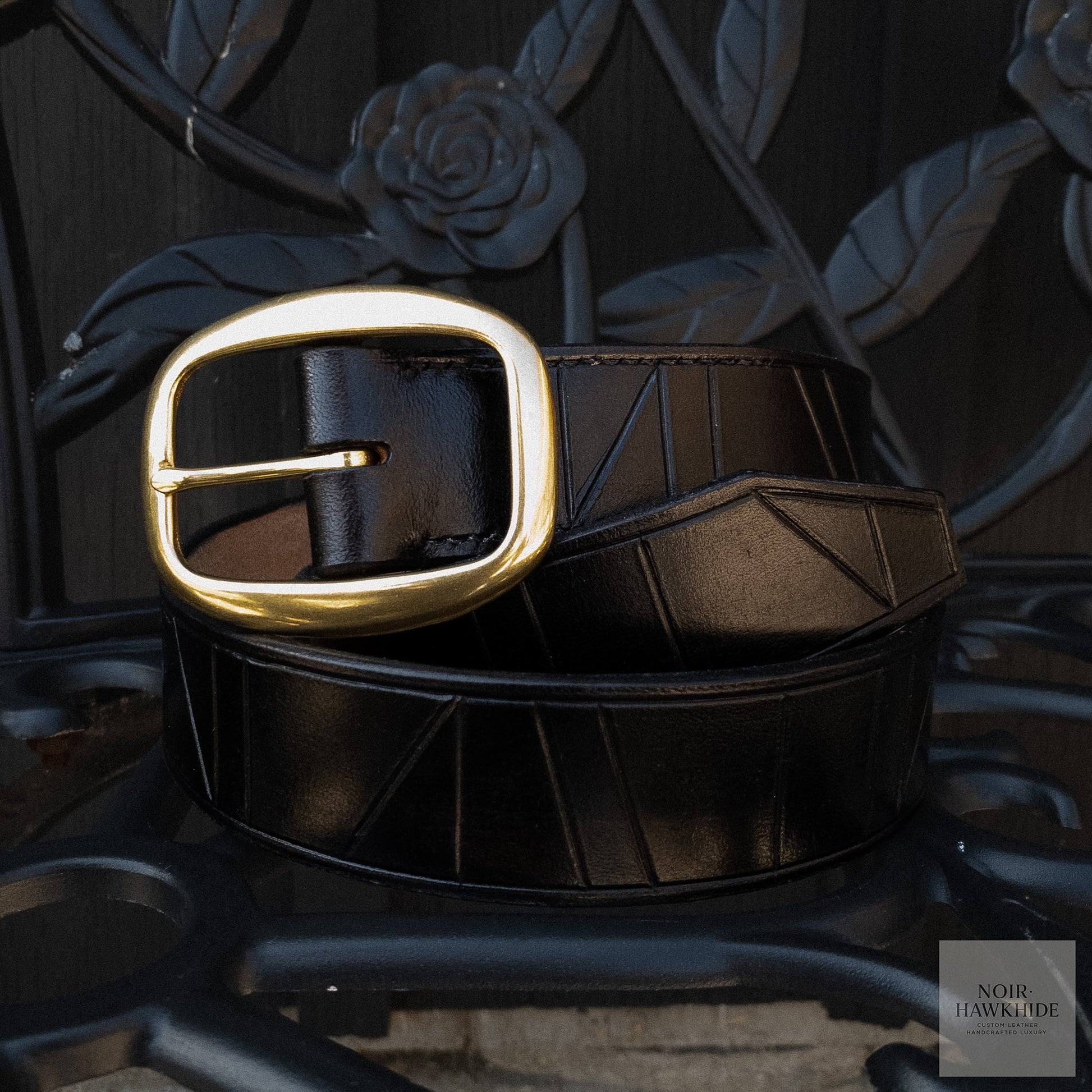 Black handcrafted leather belt with geometric hand-tooled design and solid brass buckle.