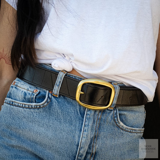 Handcrafted black leather belt styled with blue jeans and a white t-shirt.