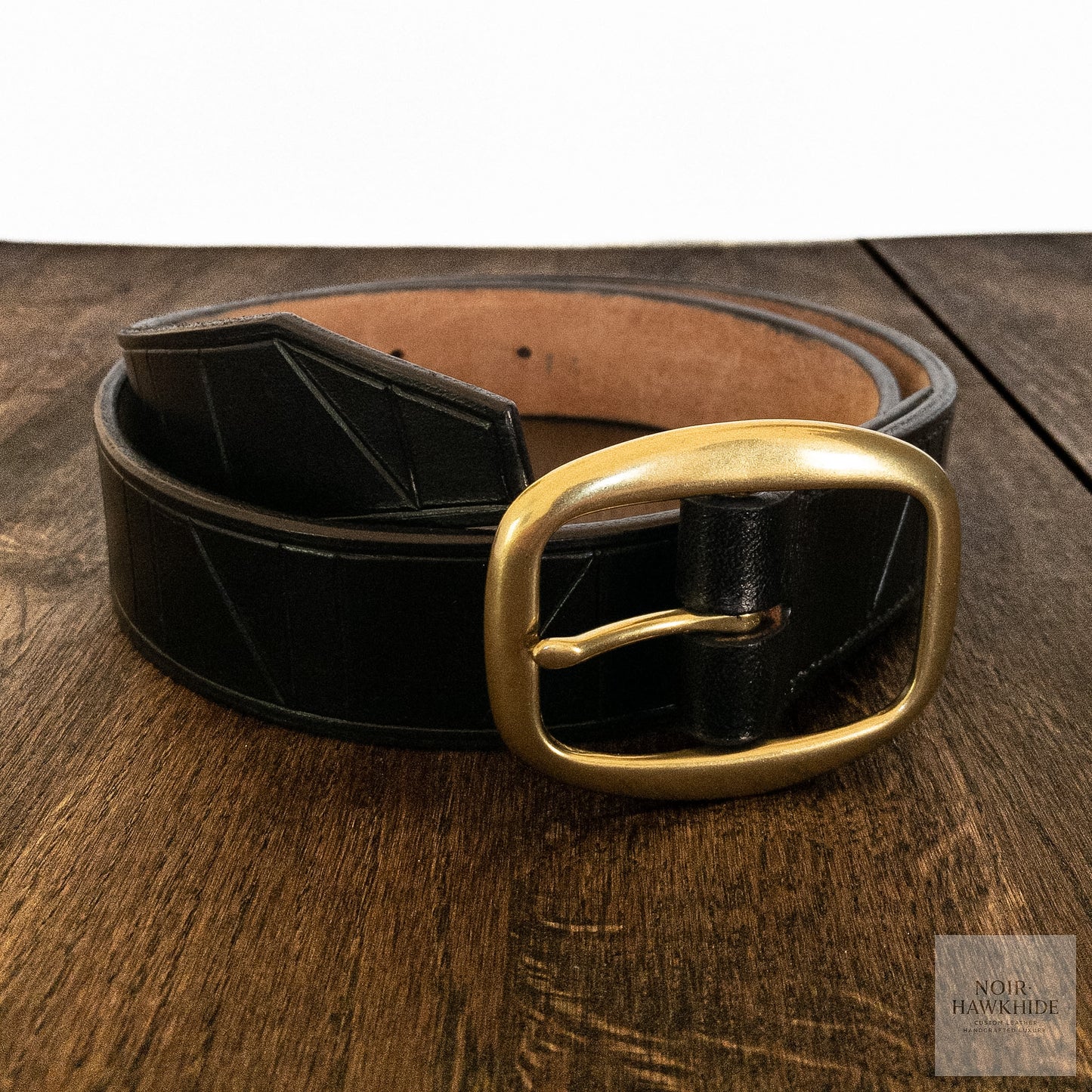 Handcrafted black leather belt with geometric hand-tooled pattern and solid brass buckle.
