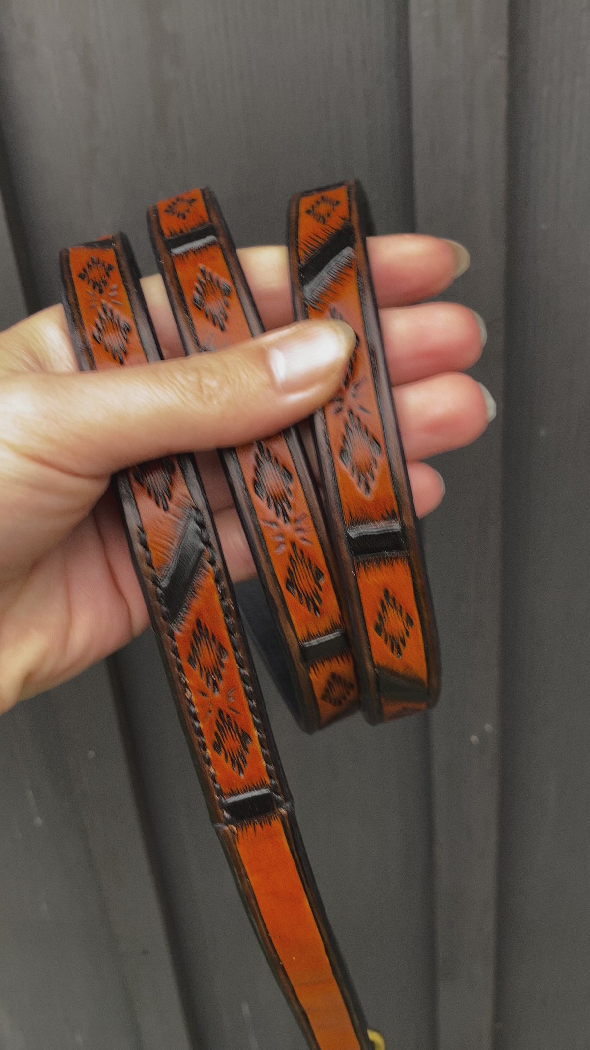 Close-up video of handmade Western Geometric leather dog leash with hand-tooled pattern, black accents and Spanish Brown finish