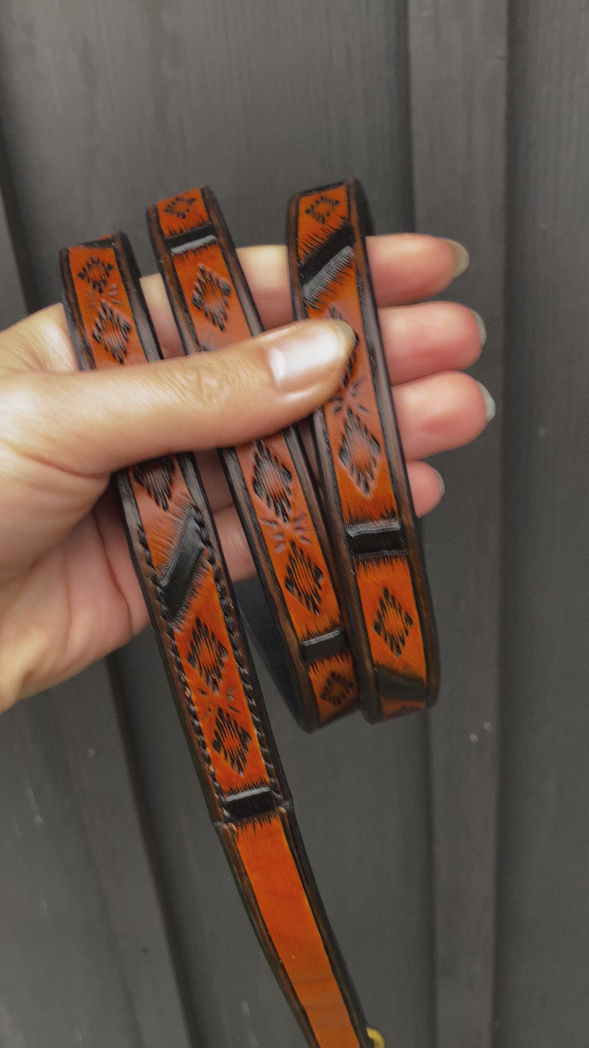 Close-up video of handmade Western Geometric leather dog leash with hand-tooled pattern, black accents and Spanish Brown finish