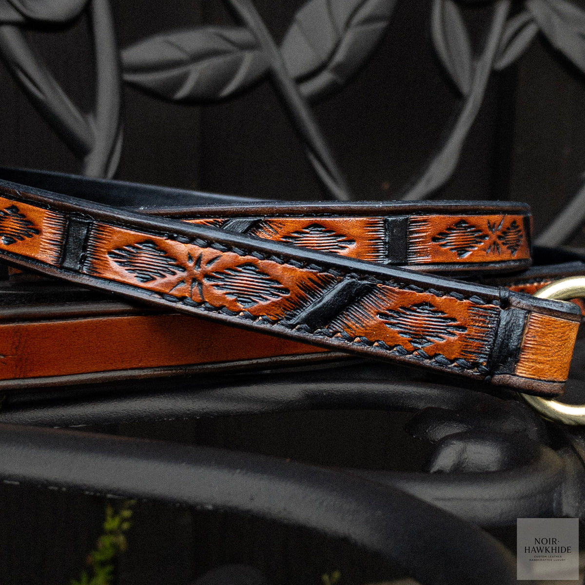 Close-up of handmade Spanish Brown leather dog leash with detailed Western geometric hand tooling, black accents and hand stitching